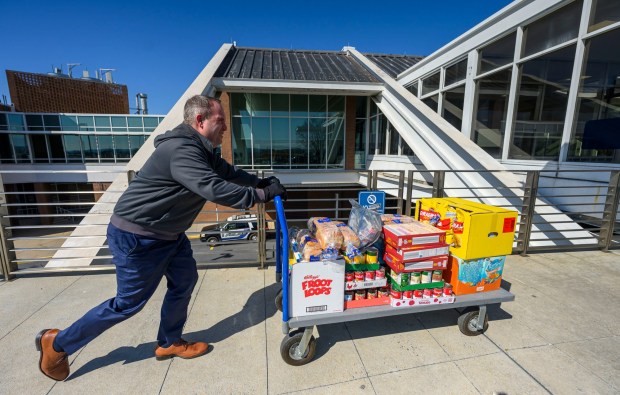 Lehigh-Northampton Airport Authority spokesperson Colin Riccobon pushes a cart toward a Transportation Security Administration area to be scanned then organized during a Fill the Bus donation drive Thursday, March 19, 2026, at Lehigh Valley International Airport. More than 20 carts were filled with donated paper products; toiletries, diapers and other baby products; gift cards; and nonperishable foods and beverages for TSA and Federal Aviation Administration workers at the airport who aren't being paid during the partial federal government shutdown. (April Gamiz/The Morning Call)
