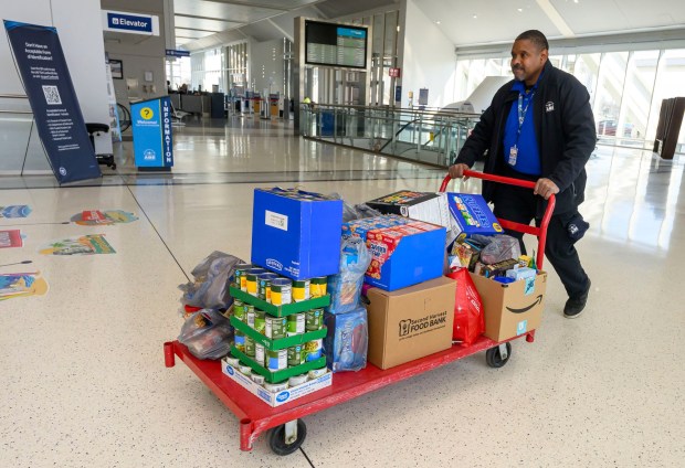 Robert Tyler, passengers service shuttle personnel, pushes a cart toward a Transportation Security Administration area to be scanned then organized during a Fill the Bus donation drive Thursday, March 19, 2026, at Lehigh Valley International Airport. More than 20 carts were filled with donated paper products; toiletries, diapers and other baby products; gift cards; and nonperishable foods and beverages for TSA and Federal Aviation Administration workers at the airport who aren't being paid during the partial federal government shutdown. (April Gamiz/The Morning Call)