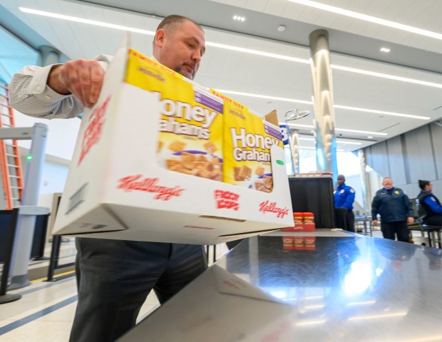 Transportation security manager Brian Weaver loads donated items onto a conveyer belt to be scanned by Transportation Security Administration workers during a Fill the Bus donation drive Thursday, March 19, 2026, at Lehigh Valley International Airport. More than 20 carts were filled with donated paper products; toiletries, diapers and other baby products; gift cards; and nonperishable foods and beverages for TSA and Federal Aviation Administration workers at the airport who aren't being paid during the partial federal government shutdown. (April Gamiz/The Morning Call)