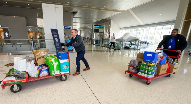 Lehigh-Northampton Airport Authority spokesperson Colin Riccobon and Robert Tyler, passengers service shuttle personnel, push carts toward a Transportation Security Administration area to be scanned then organized during a Fill the Bus donation drive Thursday, March 19, 2026, at Lehigh Valley International Airport. More than 20 carts were filled with donated paper products; toiletries, diapers and other baby products; gift cards; and nonperishable foods and beverages for TSA and Federal Aviation Administration workers at the airport who aren't being paid during the partial federal government shutdown. (April Gamiz/The Morning Call)