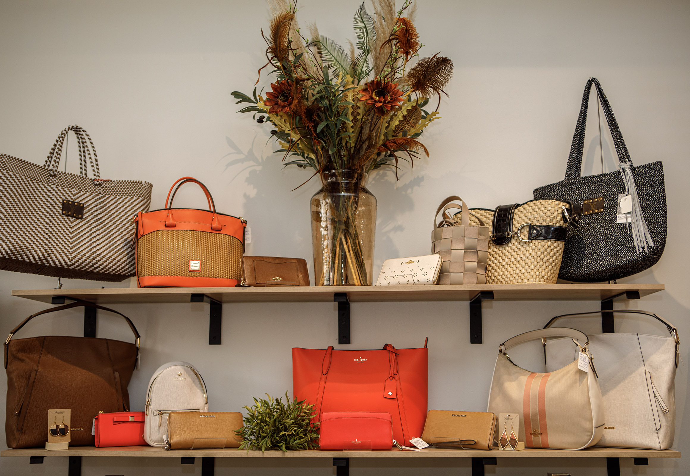 A handbag display inside Indulge Designer Resale Boutique poses inside...