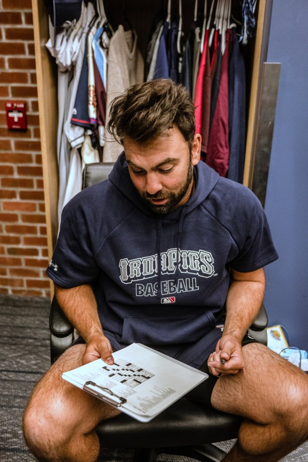 Lehigh Valley IronPigs Lou Trivino sits at his locker inside the IronPigs clubhouse on Wednesday, March 25, 2026, working on a crossword puzzle during media day at Coca-Cola park in Allentown. (Monica Cabrera/The Morning Call)