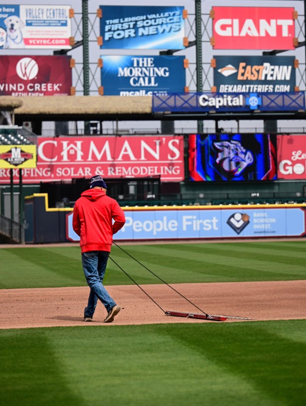 A worker smooths the infield baseline with a drag mat Wednesday, March 25, 2026, during media day at Coca-Cola park in Allentown. (Monica Cabrera/The Morning Call)