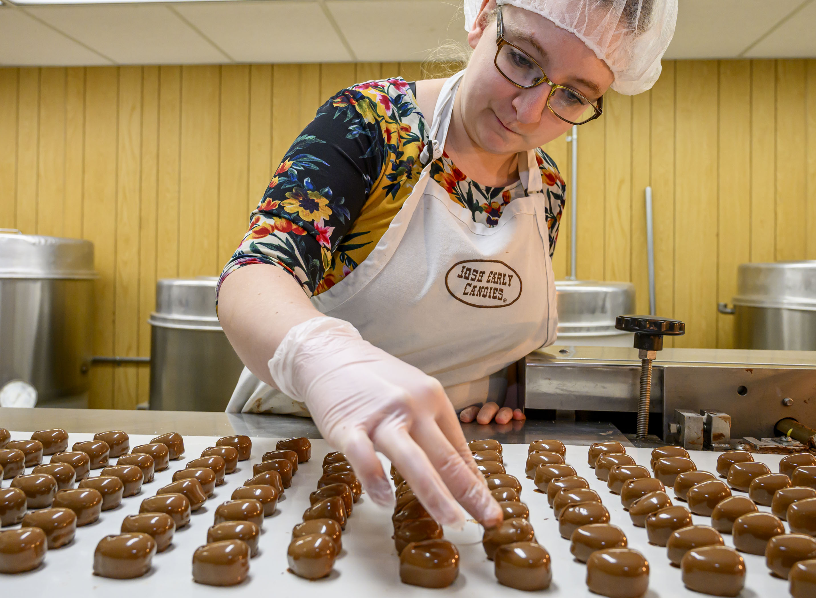 Laura Ruggiero quickly marks peanut butter cream eggs with a...