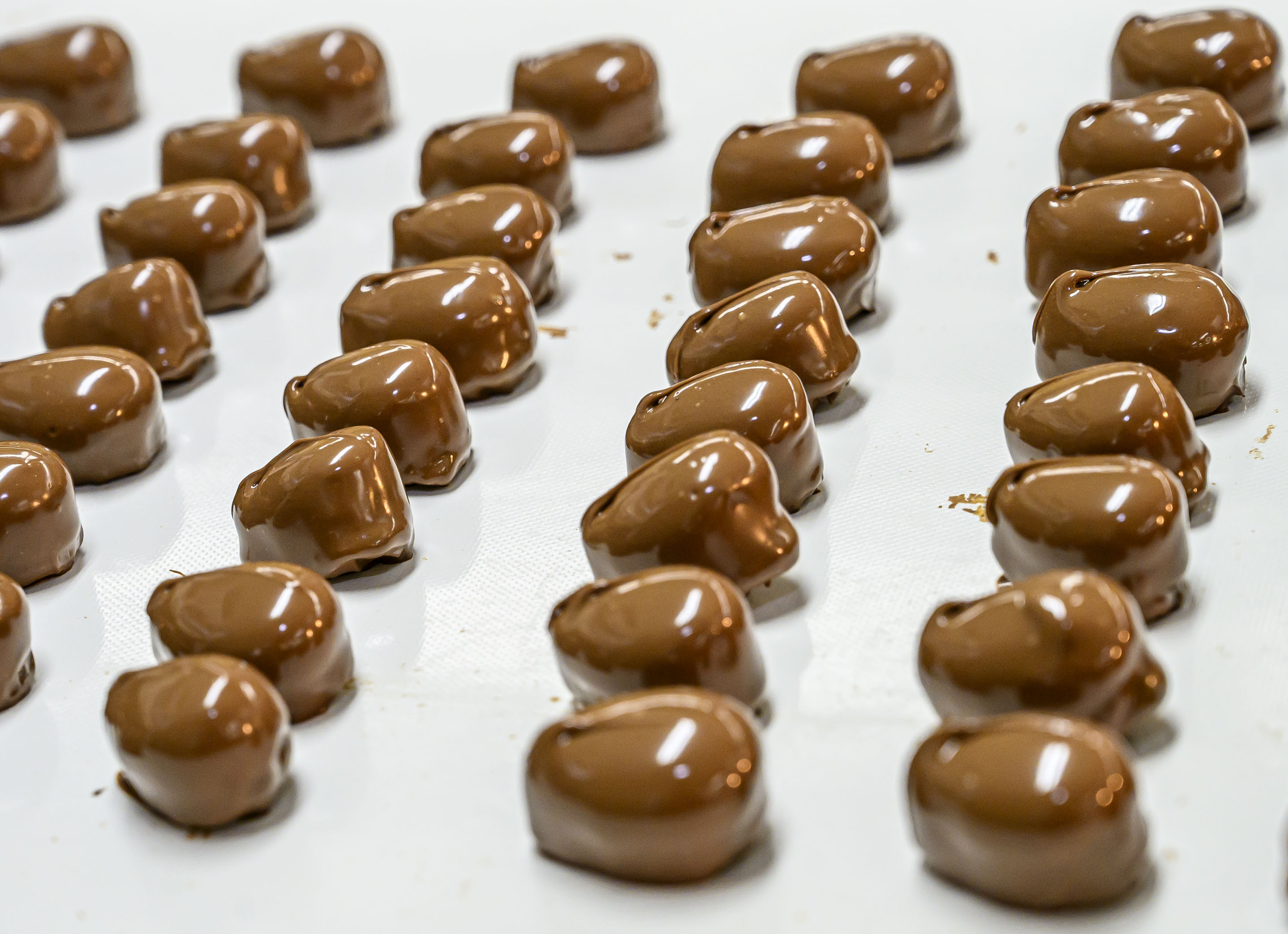 Laura Ruggiero quickly marks peanut butter cream eggs with a...