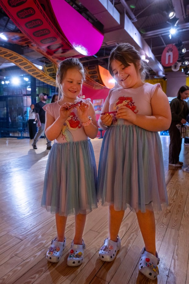 Sisters Emily Stewart, 5, and Olivia Stewart, 7, look at their personalized Red Violet crayons Monday, March 30, 2026, at the Crayola Experience in Easton. They were excited because they had just arrived already found a letter "N" hanging from the ceiling as part of a scavenger hunt activity leading up to National Crayon Day on Tuesday. Hundreds of crayon lovers will be celebrating with Crayola Experience, kicking off the brand's Million Crayon Giveaway by creating their free, one-of-a-kind crayon box. Families registered for the giveaway will have the colorful experience of customizing a 32-count crayon box with any color assortment of their favorite Crayola crayons from a 40-foot-long Pick Your Pack wall holding nearly half a million crayonsincluding the official return of the beloved Crayola color Dandelionfor good. (Monica Cabrera/The Morning Call)