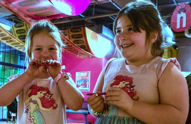 Sisters Emily Stewart, 5, and Olivia Stewart, 7, look at their personalized Red Violet crayons Monday, March 30, 2026, at the Crayola Experience in Easton. They were excited because they had just arrived already found a letter "N" hanging from the ceiling as part of a scavenger hunt activity leading up to National Crayon Day on Tuesday. Hundreds of crayon lovers will be celebrating with Crayola Experience, kicking off the brand's Million Crayon Giveaway by creating their free, one-of-a-kind crayon box. Families registered for the giveaway will have the colorful experience of customizing a 32-count crayon box with any color assortment of their favorite Crayola crayons from a 40-foot-long Pick Your Pack wall holding nearly half a million crayonsincluding the official return of the beloved Crayola color Dandelionfor good. (Monica Cabrera/The Morning Call)