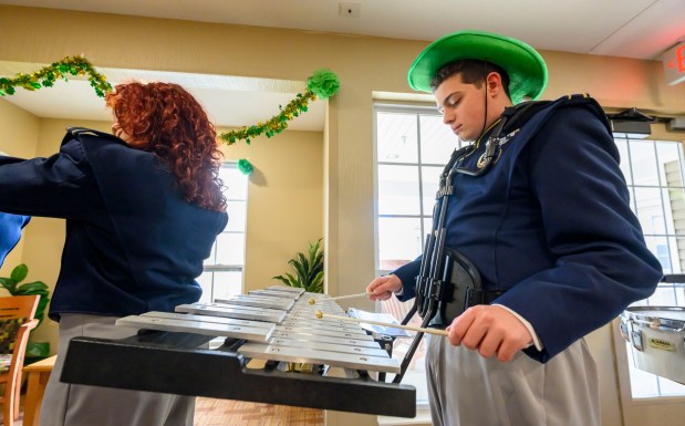 Michael Selvaggil, a member of the Notre Dame-Green Pond Crusaders Band, plays the bells and marches Tuesday, March 17, 2026, during a St. Patrick's Day celebration at Arden Courts Old Orchard, a memory care community, in Bethlehem Township. (April Gamiz/The Morning Call)