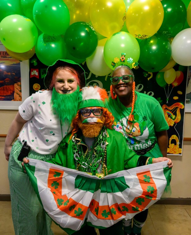 Emily Cali and Mary Altema pose with Lucky the "Leprechaun" on Tuesday, March 17, 2026, during a St. Patrick's Day celebration at Arden Courts Old Orchard, a memory care community, in Bethlehem Township. (April Gamiz/The Morning Call)