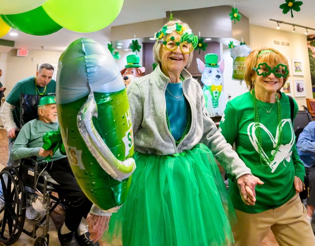 Sharon Miller walks with her mother-in-law, Betty, a resident at Arden Courts Old Orchard memory care community in Bethlehem Township, during a St. Patrick's Day celebration Tuesday, March 17, 2026 at Arden Courts. (April Gamiz/The Morning Call)