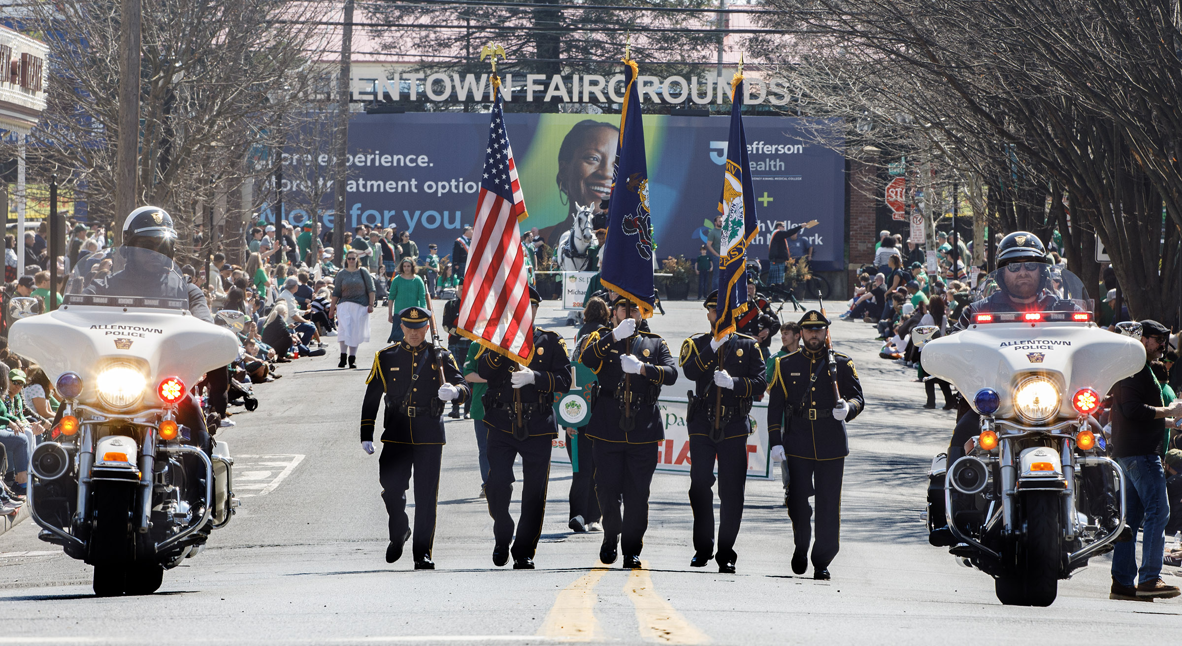 People line the streets during the start of the St....