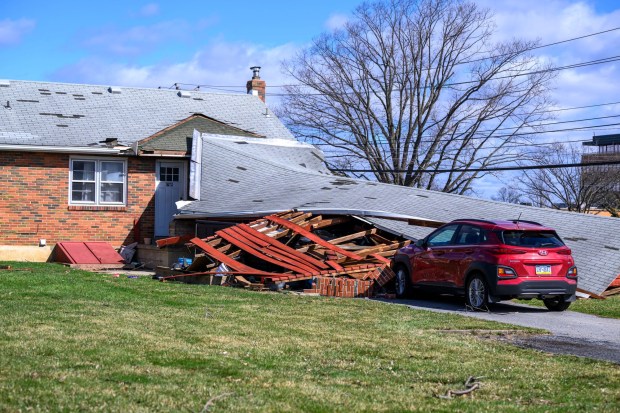 Storm damage from Monday night's strong winds is seen Tuesday, March 17, 2026, at a house on Devonshire Road in Allentown. Storms blew off roofs and downed trees and power lines around the Lehigh Valley, leaving thousands without electricity. (April Gamiz/The Morning Call)