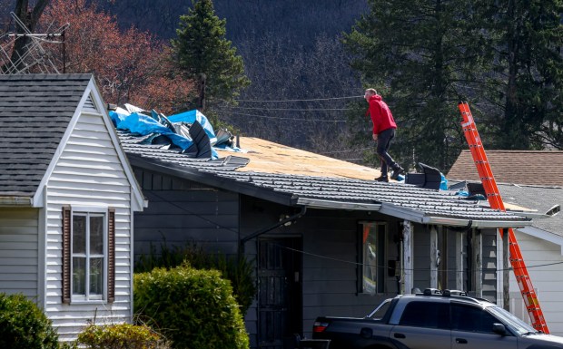 Scott Grub of Advanced Disaster Recovery Inc. inspects a roof Tuesday, March 17, 2026, on South 12th Street in Allentown after it was damaged by Monday night's strong winds. Storms blew off roofs and downed trees and power lines around the Lehigh Valley, leaving thousands without electricity. (April Gamiz/The Morning Call)