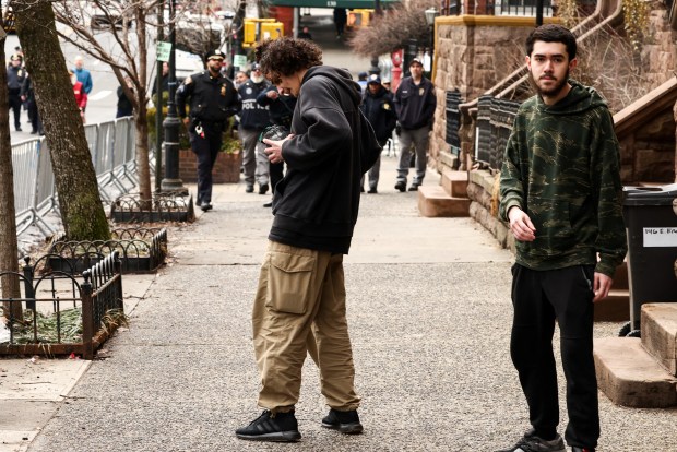 Emir Balat (left) lights a homemade explosive device before throwing it towards police during a protest organized by far-right influencer Jake Lang against alleged "Islamification" in New York City, near Gracie Mansion on the Upper East Side of Manhattan on Saturday, March 7, 2026. At right is Balat's alleged partner in crime, Ibrahim Kayumi. (Photo by CHARLY TRIBALLEAU / AFP via Getty Images)