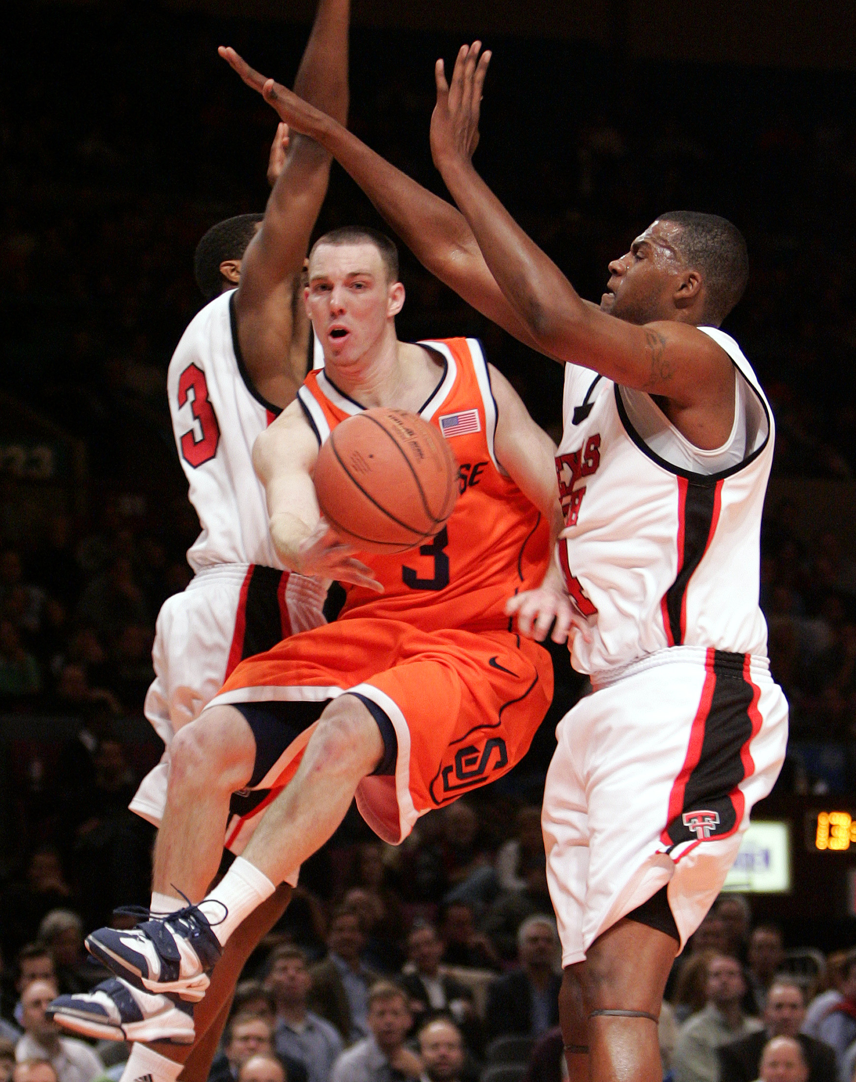 Syracuse guard Gerry McNamara, center, passes the ball off between...