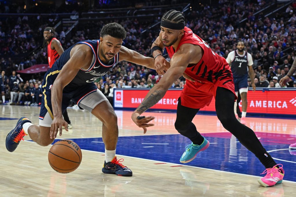 Mar 15, 2026; Philadelphia, Pennsylvania, USA; Philadelphia 76ers guard Quentin Grimes (5) is defended by Portland Trail Blazers forward Toumani Camara (33) during the second half at Xfinity Mobile Arena.