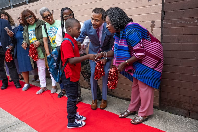 Philadelphia schools Superintendent Tony B. Watlington Sr, center, and Mayor Cherelle L. Parker, greet a student at Edward T. Steel School on the first day of the 2025-26 school year in August. The district is facing steep budget cuts for next school year.