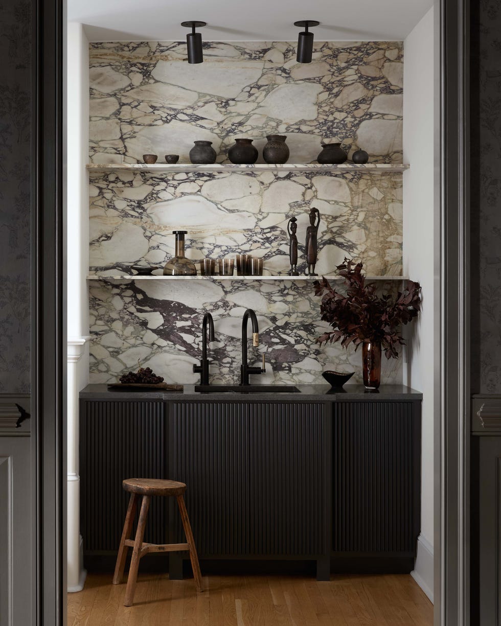 Modern kitchen nook with dark cabinetry and marble backsplash.