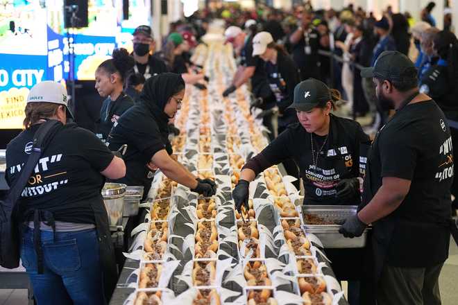 Volunteers assemble cheesesteaks in a Guinness World Record attempt on National Cheesesteak Day at Philadelphia International Airport, Tuesday, March 24, 2026, in Philadelphia.