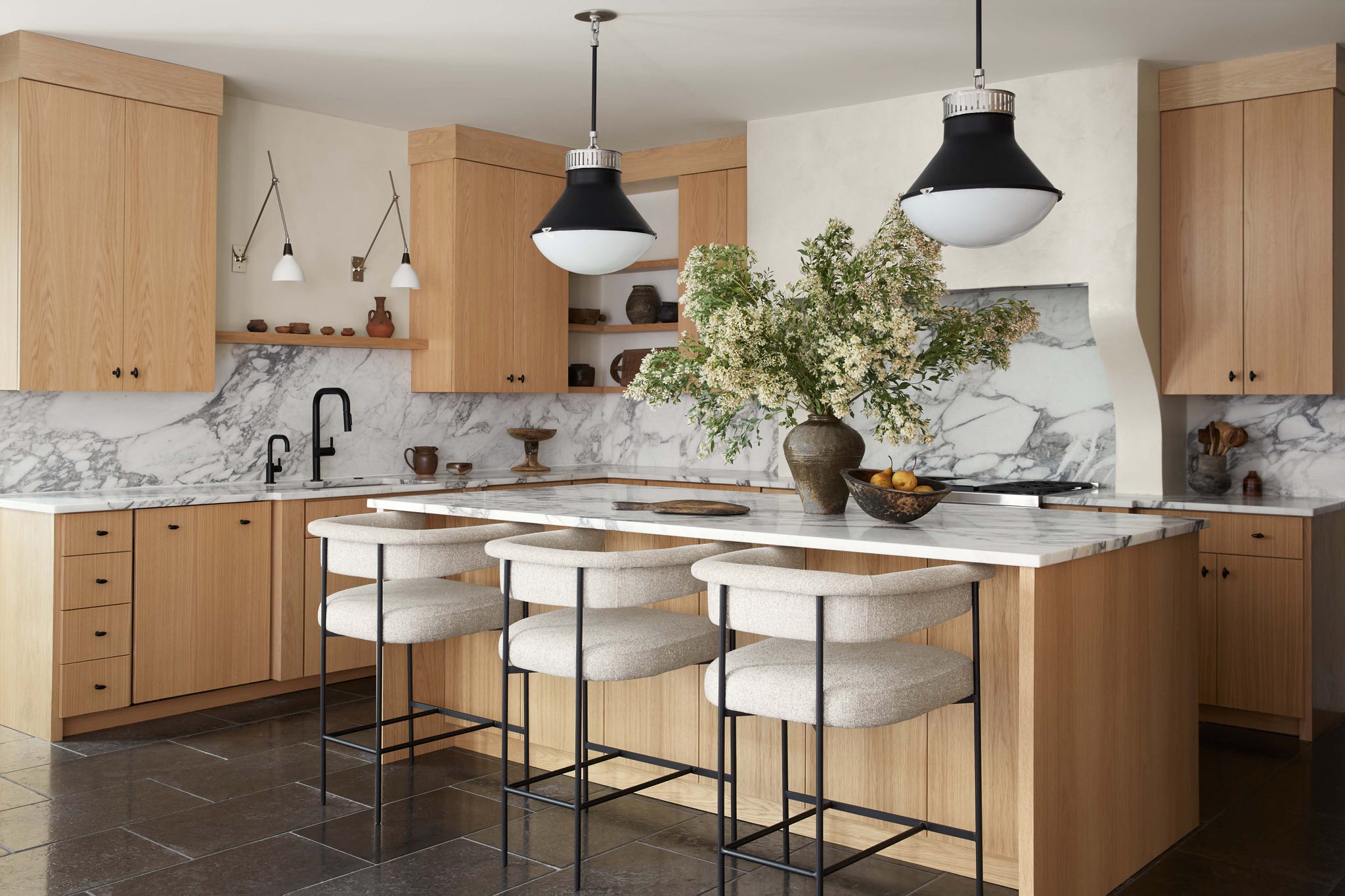 Modern kitchen with marble countertops and wooden cabinetry.
