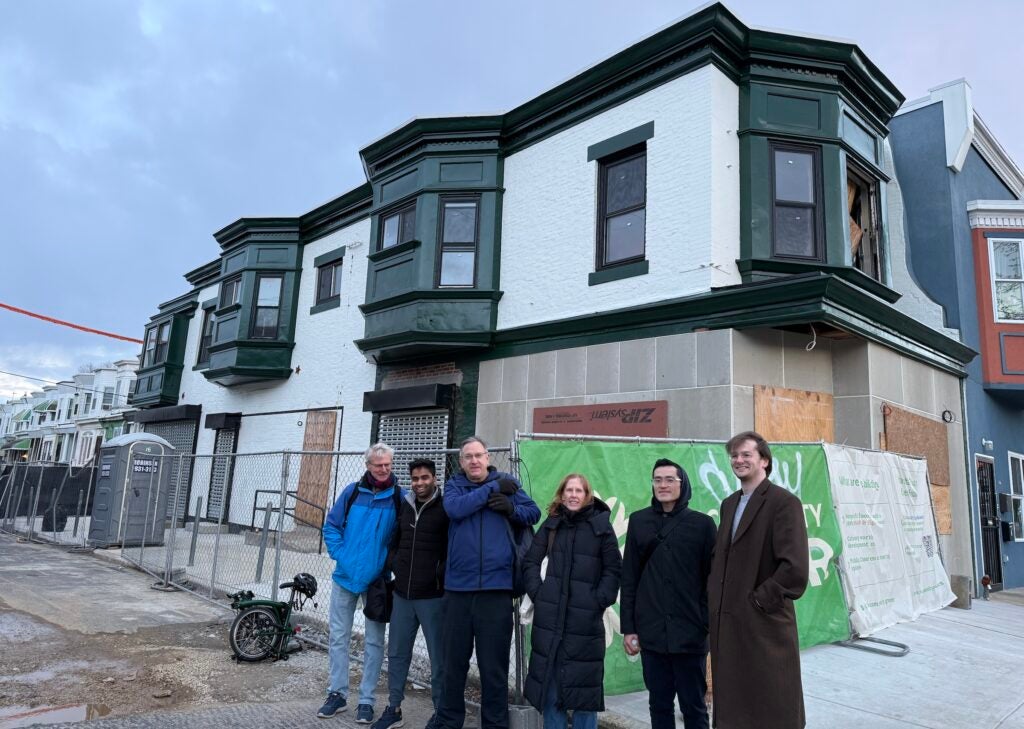 A group of people posing for a photo outside of the construction site.
