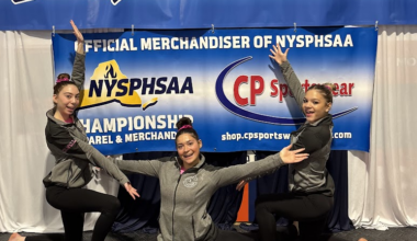 student athletes pose in front of banner