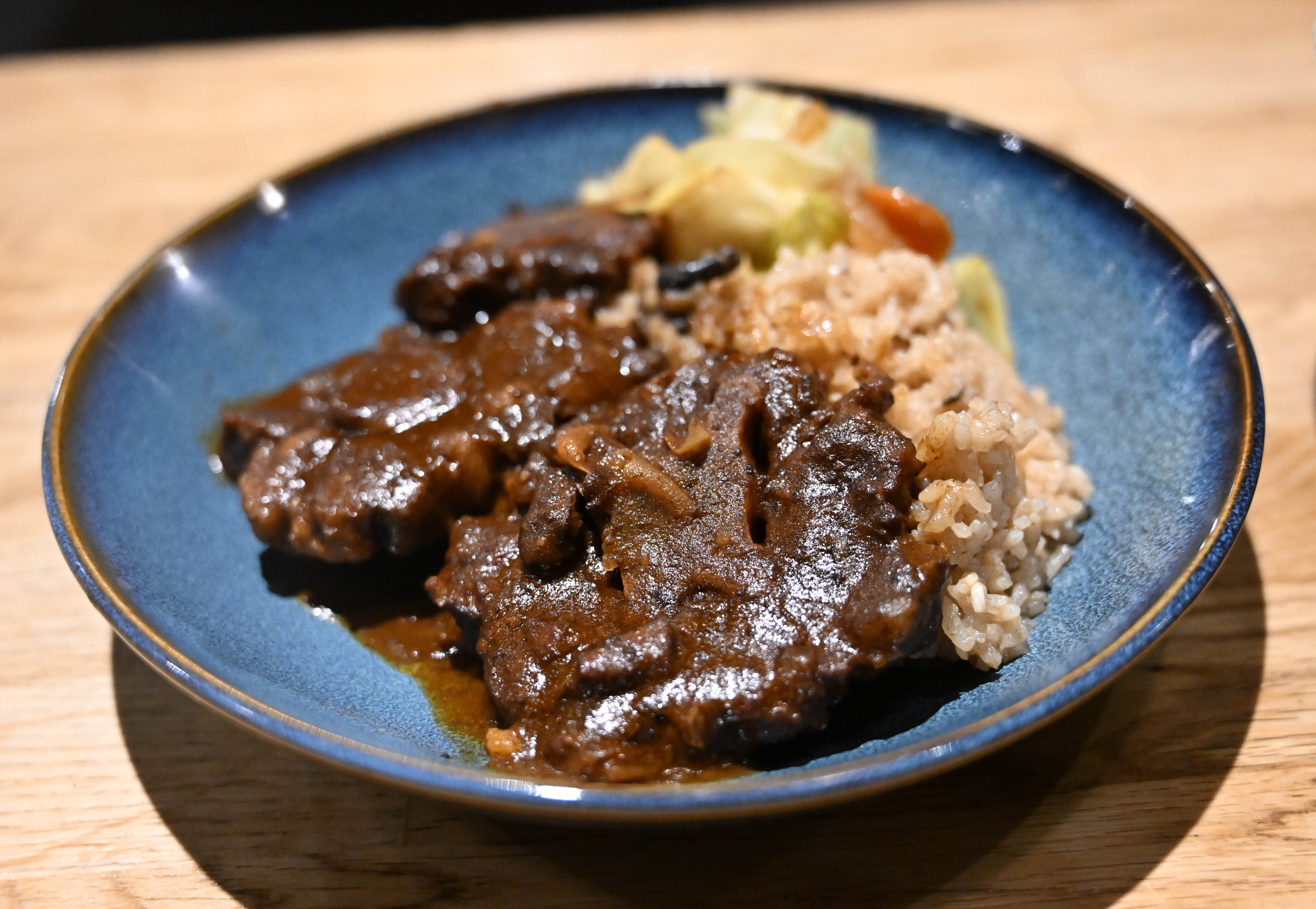 Dish oxtail with coconut rice and steamed cabbage is seen...