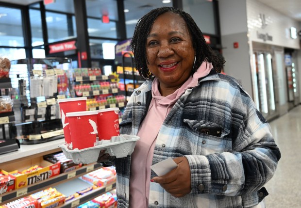 Betty Odotte holds up her coffee order during the grand opening of the new Wawa store Thursday, March 12, 2026, in Whitehall Township. (Amy Shortell/The Morning Call)