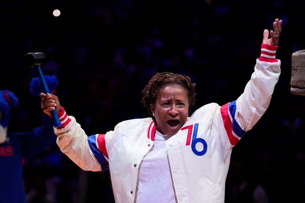 Wanda Sykes raises her arms and cheers before a Philadelphia 76ers game