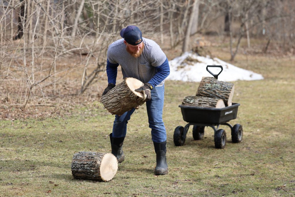 person lifting logs