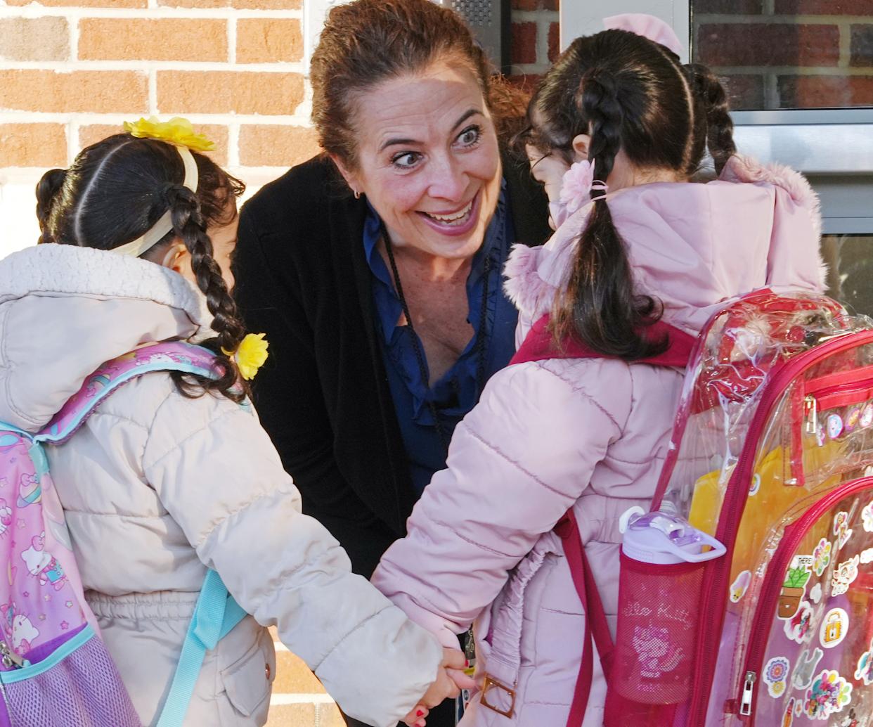 Edison Elementary School principal Diane Sutton greets students entering the new building.
