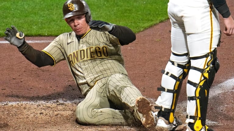 San Diego Padres' Freddy Fermin, left, scores behind Pittsburgh Pirates...