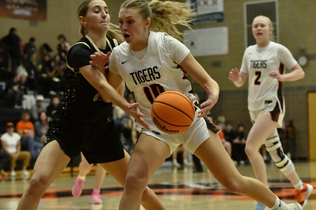 Erie's Juliet Slater looks for a path to the basket around Rock Canyon's Anna Spielmann during the Tigers' home Class 6A state tournament game against Rock Canyon on Feb. 28, 2026. (Alissa Noe/BoCoPreps.com)