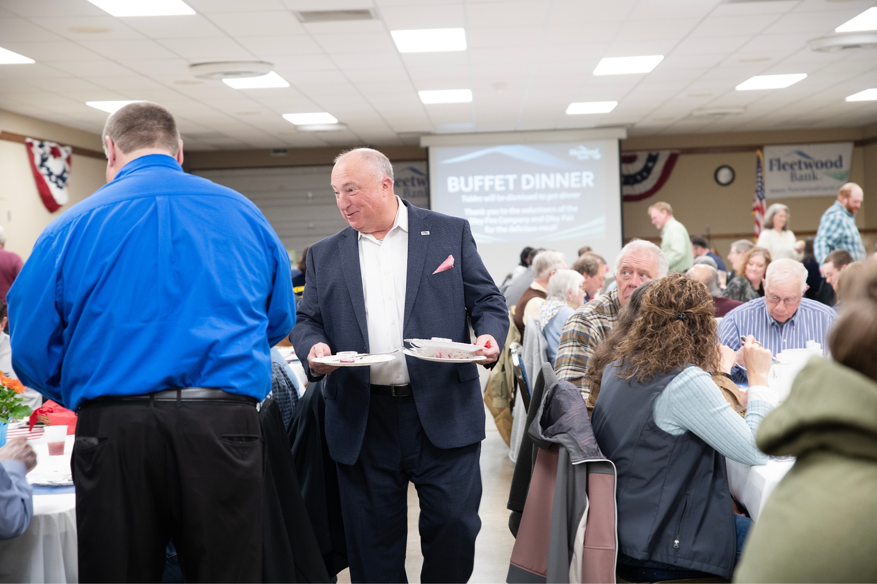 Tim Snyder, president and CEO of Fleetwood Bank, clears plates...