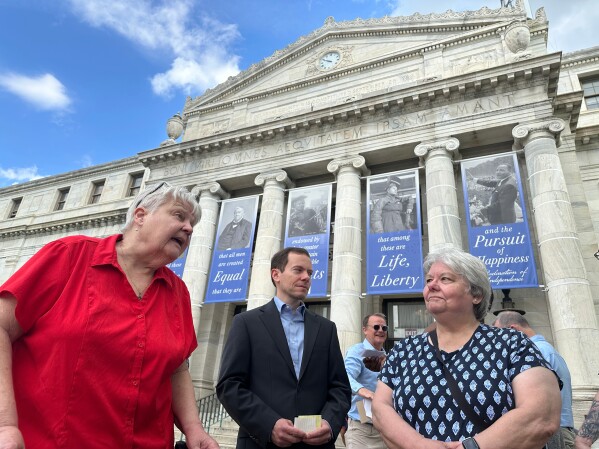 Judy Prichard McCleary, left, and Greg Prichard, center, whose relatives' burial sites were disturbed in a crime spree involving the theft of more than 100 bodies from Pennsylvania cemeteries, speak with reporters outside the Delaware County Courthouse in Media, Pa., on Firday, April 17, 2026. (AP Photo/Tassanee Vejpongsa) CORRECTION: day of the week to Friday, not Thursday