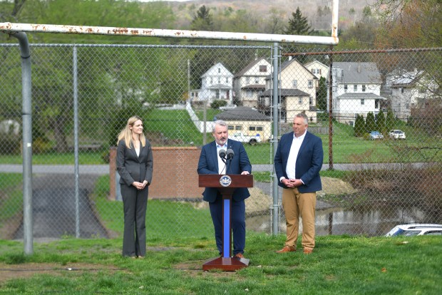 State Rep. Kyle Donahue, center, speaks with Scranton Mayor Paige Gebhardt Cognetti and Pennsylvania Emergency Management Agency (PEMA) Deputy Director for Recovery Larry West at the West Scranton Field Friday, April 17, 2026. (SEAN MCKEAG / STAFF PHOTOGRAPHER)