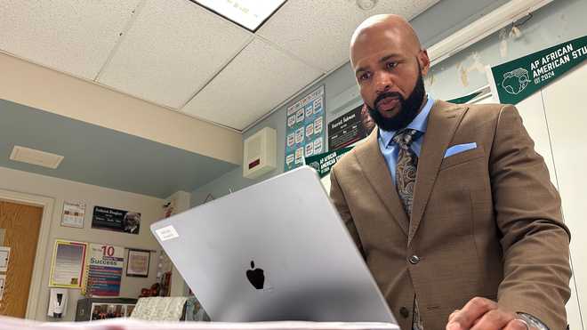 Leon Smith, named the 2026 National Teacher of the Year, stands in front of his classroom at Haverford High School, in Havertown, Pa. on Monday, April 20, 2026. (AP Photo/Tassanee Vejpongsa)