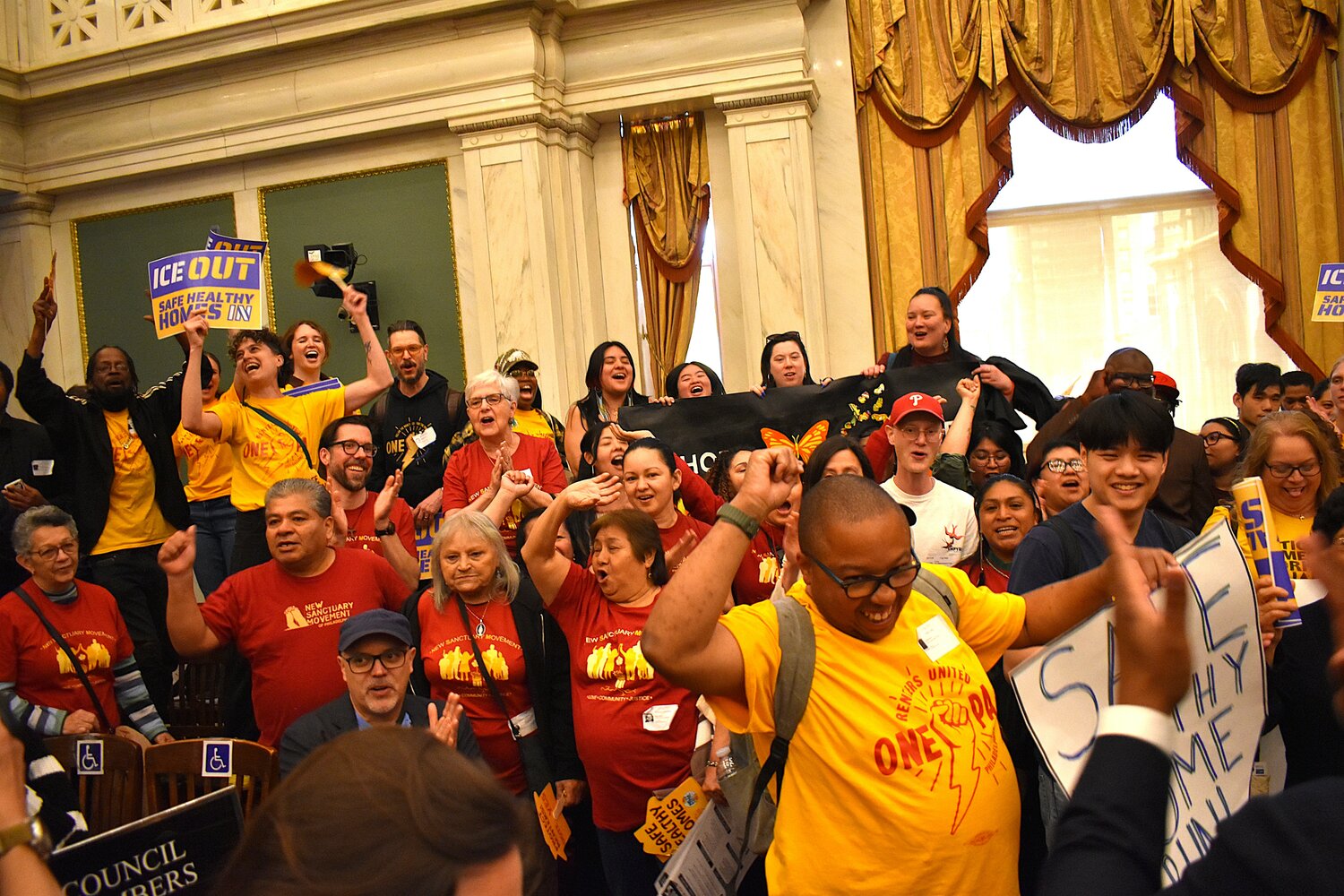 Supporters of the "ICE Out" and "Safe Healthy Homes" legislation celebrate after City Council approved the bills Thursday, April 23, 2026.