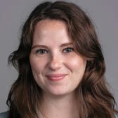 Samantha Grindell's face on a gray background.