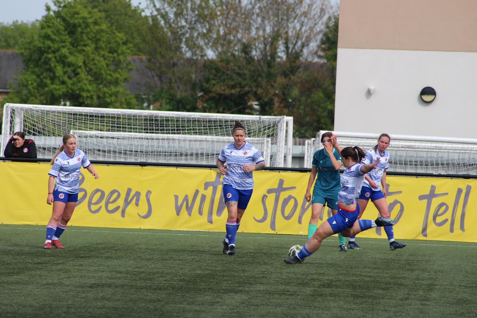 Hat-trick hero Nat Cowell strikes the ball as Ellie Szekeres (L), Georgia Hayes and Bethan Poole (R) look on