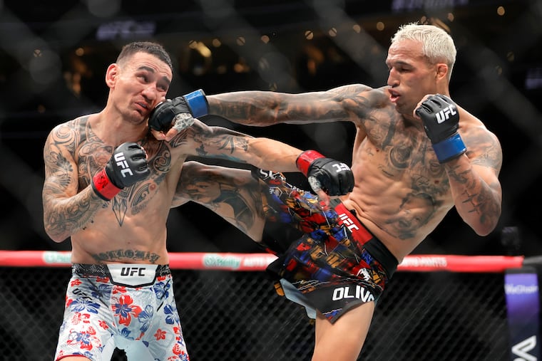 Charles Oliveira (right) punches Max Holloway in a lightweight fight during UFC 326 in March. UFC will be back in Philly in August for it's first title bout in 15 years.