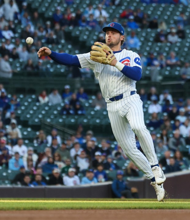 Cubs second baseman Nico Hoerner throws to first base for an out on Phillies designated hitter Bryce Harper in the first inning at Wrigley Field on April 22, 2026, in Chicago. (John J. Kim/Chicago Tribune)