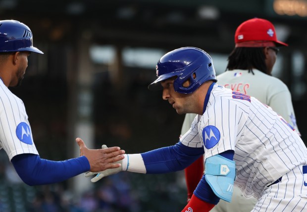 Cubs third baseman Alex Bregman, right, is congratulated after hitting a single against the Phillies in the first inning at Wrigley Field on April 22, 2026, in Chicago. (John J. Kim/Chicago Tribune)