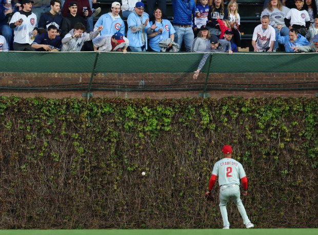 Fans cheer as a ball hit by Cubs center fielder Pete Crow-Armstrong hits the ivy for an RBI double in the second inning against the Phillies at Wrigley Field on April 22, 2026, in Chicago. (John J. Kim/Chicago Tribune)