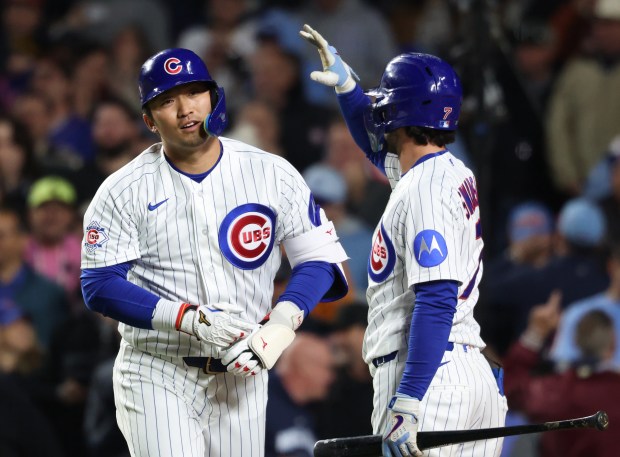 Cubs right fielder Seiya Suzuki, left, heads to the dugout after hitting a two-run home run in the fifth inning against the Phillies at Wrigley Field on April 22, 2026, in Chicago. (John J. Kim/Chicago Tribune)
