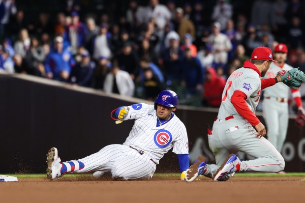 Cubs designated hitter Moisés Ballesteros slides ahead of Phillies shortstop Trea Turner for a double in the eighth inning at Wrigley Field on April 22, 2026, in Chicago. (John J. Kim/Chicago Tribune)