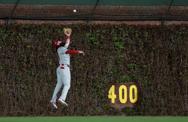Philadelphia Phillies center fielder Brandon Marsh makes a leaping catch of a long fly ball hit by Chicago Cubs designated hitter Alex Bregman to end the top of the fourth inning of a game at Wrigley Field in Chicago on April 21, 2026. (Chris Sweda/Chicago Tribune)