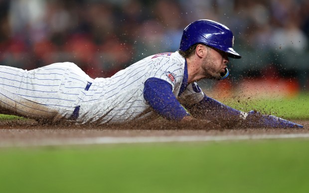 Chicago Cubs second baseman Nico Hoerner slides into third base as he advances from first base on a single by teammate Ian Happ in the sixth inning of a game against the Philadelphia Phillies at Wrigley Field in Chicago on April 21, 2026. (Chris Sweda/Chicago Tribune)