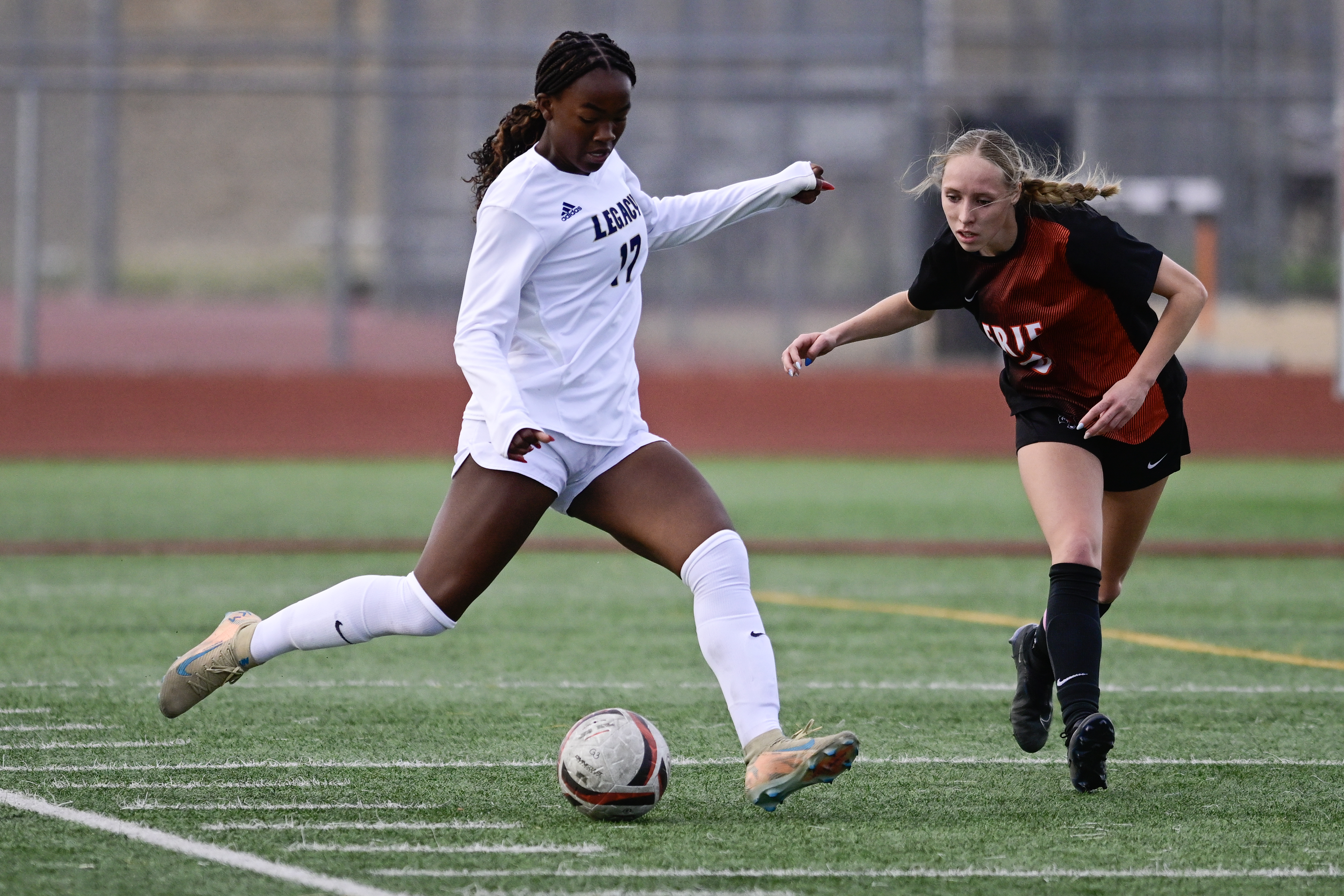 Legacyâs Anaya Bursey, left, passes the ball past Erieâs Gianna...