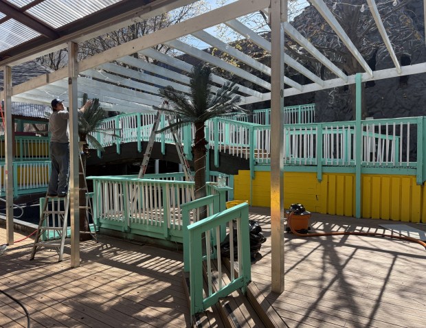 Tyler McKee hanging lights throughout the newly renovated Baja Beach Club on the day before its soft opening on April 10. The entire club was built to create a Key West vibe. (PEG DEGRASSA/ DAILY TIMES)